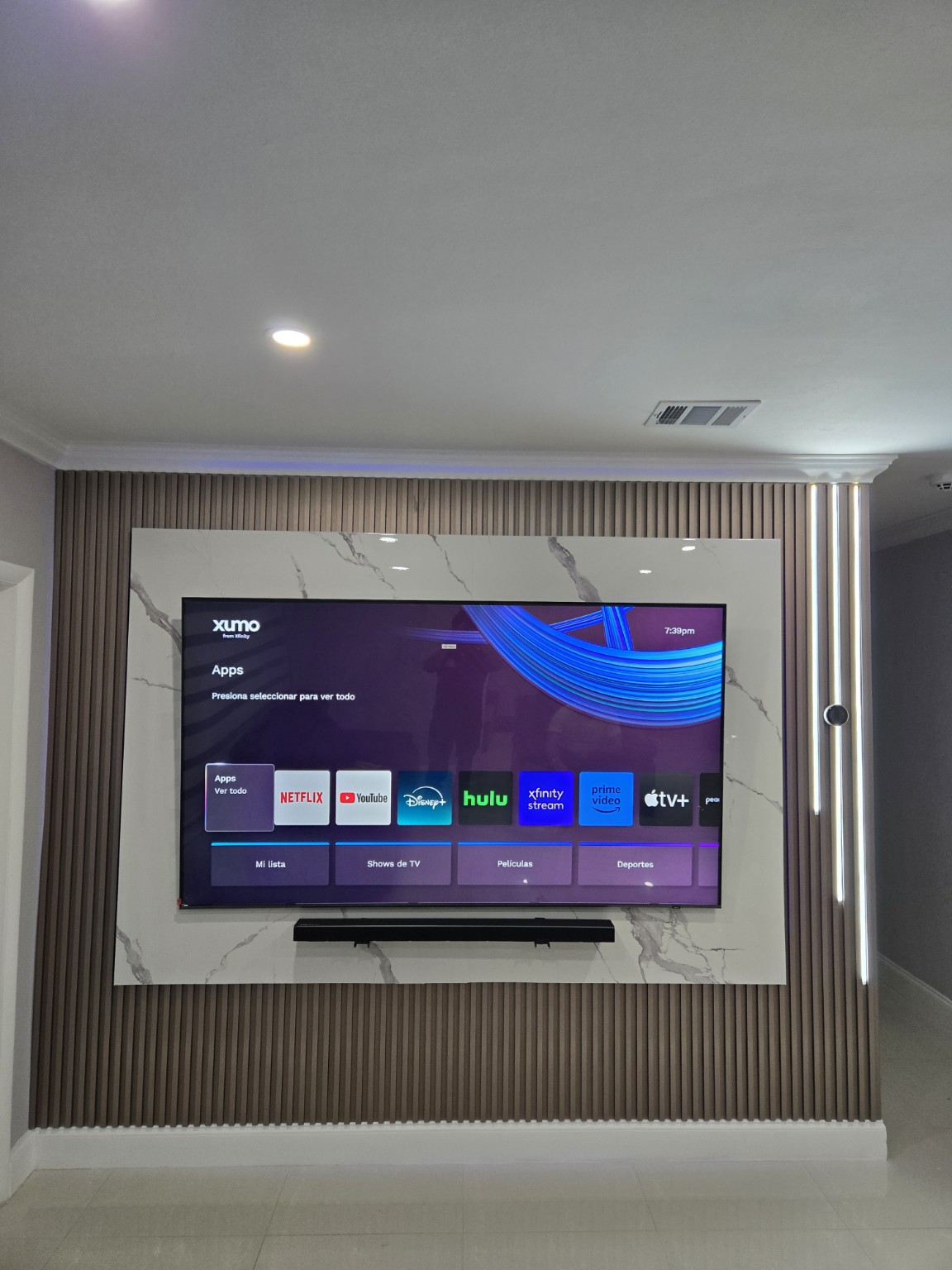 TV wall with marble-look panel and slats